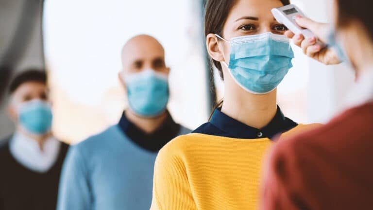 Foto: Pessoa tendo sua temperatura medida